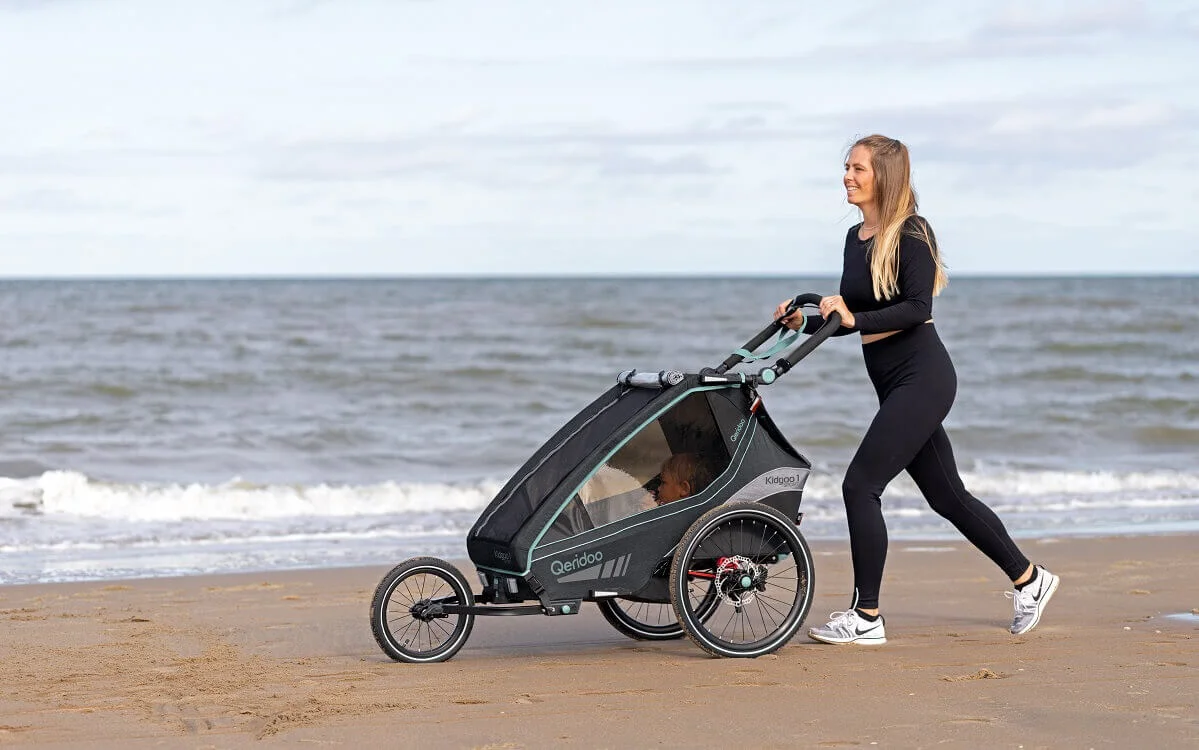 Bild Frau mit Kinderfahrradanhänger am Strand