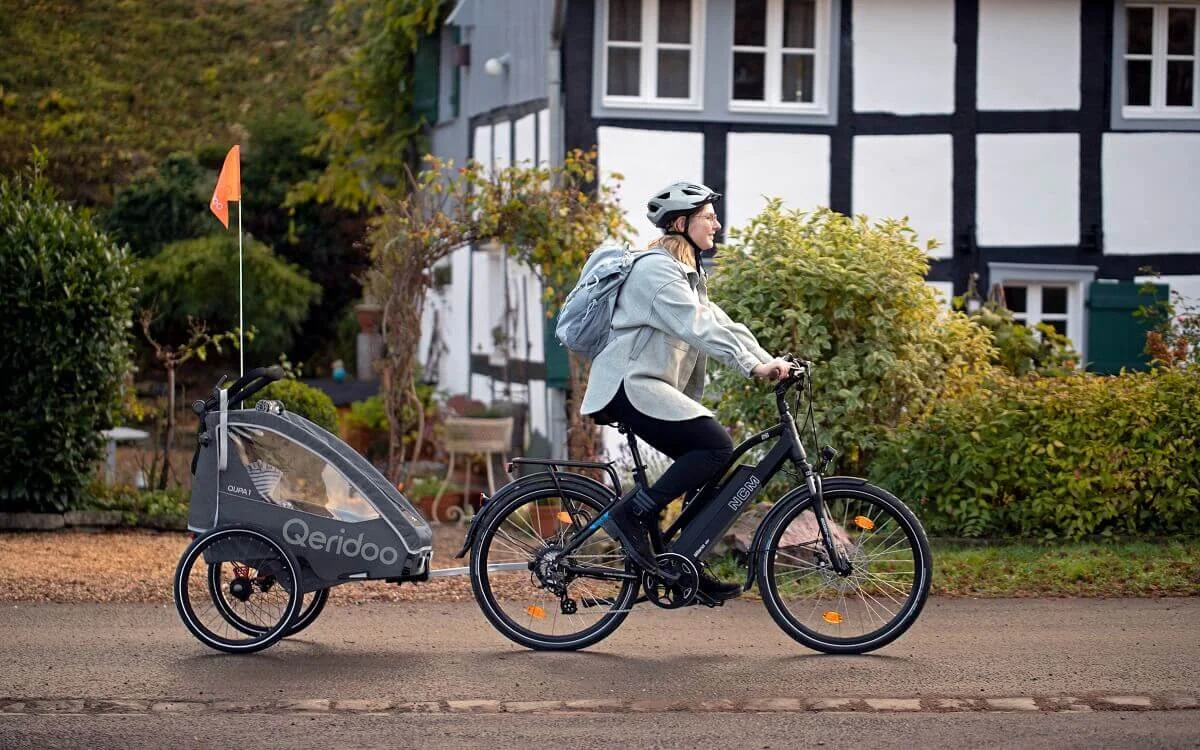 Kind mit Helm im Fahrradanhänger